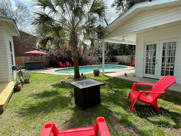 Relax by the pool surrounded by lush greenery and comfortable outdoor furniture.