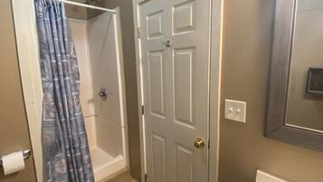 A bathroom with a shower, toilet, and sink.
