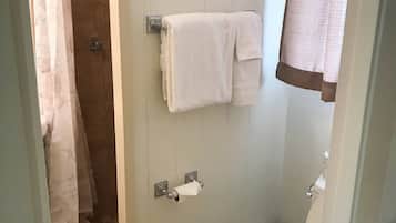 A bathroom with a shower, toilet, and towel rack.