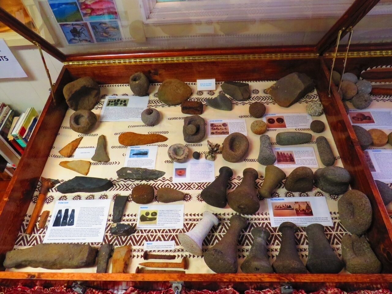 Una vitrina con diversas herramientas y artefactos de piedra, cada uno identificado con descripciones.