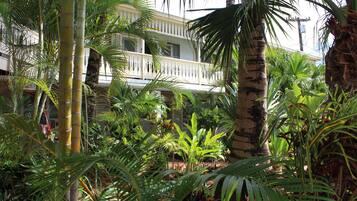 Escape to a serene tropical oasis with lush gardens and a colonial-style building.