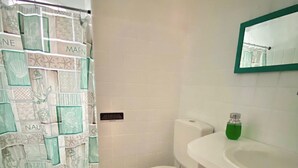 A bathroom with a white toilet, a sink, and a shower curtain with nautical patterns. - Pousada Cantinho Ossos (Búzios)