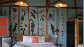 Un dormitorio con cama, refrigerador y una pared con un mural floral.