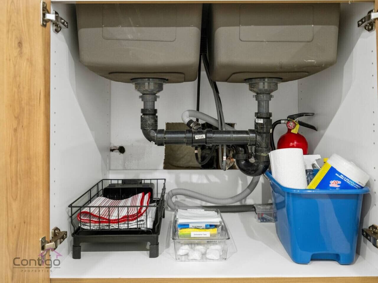 A kitchen with two sinks, a fire extinguisher, and storage containers.
