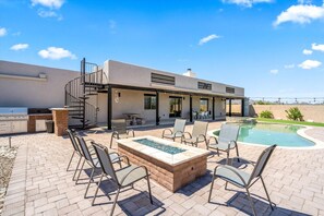 A modern house with a patio, outdoor grill, and a swimming pool. - 4BR Home w/ Mountain Views, Pool, Spa, Firepit & Gazebo (Tucson)