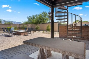 An outdoor patio with a spiral staircase, outdoor seating, and a view of mountains. - 4BR Home w/ Mountain Views, Pool, Spa, Firepit & Gazebo (Tucson)
