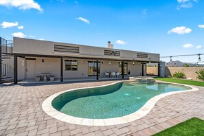 A modern house with a swimming pool, outdoor seating, and a clear view of the mountains. - 4BR Home w/ Mountain Views, Pool, Spa, Firepit & Gazebo (Tucson)