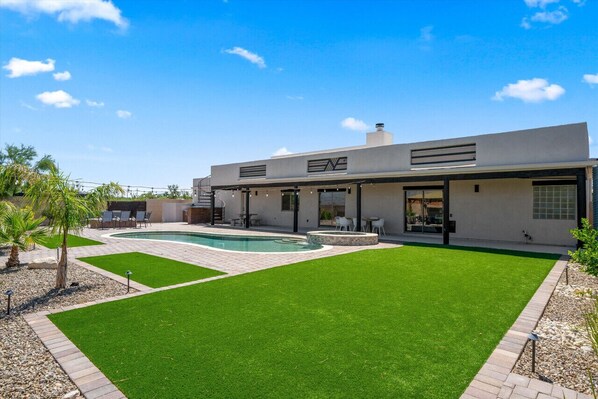 A modern house with a swimming pool, a patio, and a well-maintained lawn. - 4BR Home w/ Mountain Views, Pool, Spa, Firepit & Gazebo (Tucson)