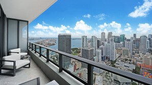 En balkon med udsigt over byen, moderne møbler og en klar himmel.
