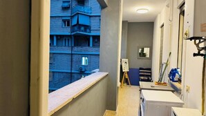 Un couloir étroit donnant sur un immeuble bleu à l’extérieur.