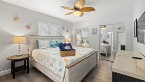 A bedroom with a bed, bedside tables, a ceiling fan, and a mirror. - Spacious and Short Drive to Beach (St. Petersburg)