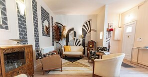 Un salon comprenant un canapé, des fauteuils, une table basse et un meuble.