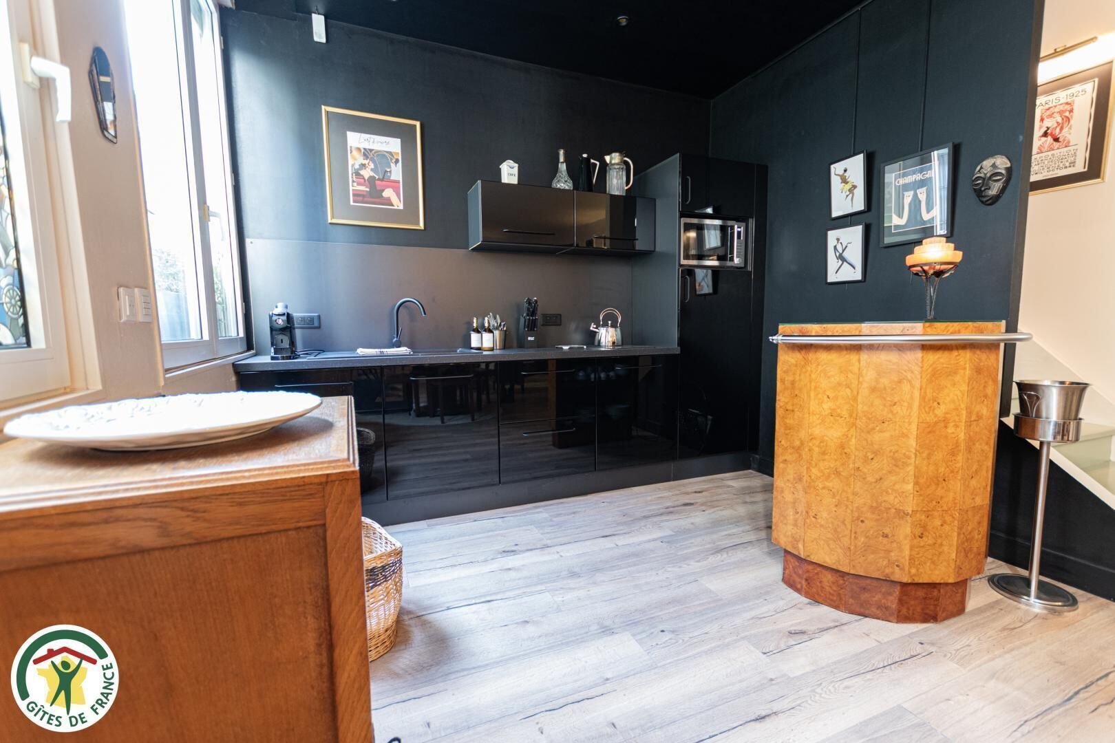 A modern kitchen with dark walls, a wooden counter, and a sink.