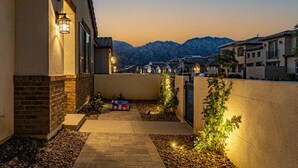 Et boligområde med huse, en belagt sti og et bjerg i baggrunden.