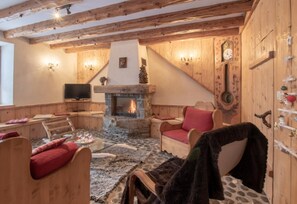 Una habitación acogedora con chimenea de piedra, muebles de madera y un televisor.