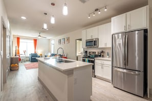 Enjoy cooking in this well-lit kitchen with a central island, sink, and stainless steel appliances.