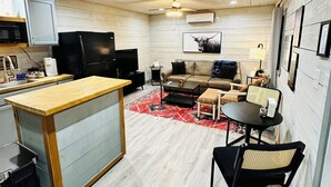 A compact living space with a kitchenette, a sofa, a coffee table, and a dining area. - Charming cottage in Springtown, TX with AC and WiFi. Enjoy your stay (Springtown)