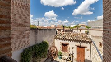 Une cour intérieure avec un bâtiment de style traditionnel, une porte en bois et une grande roue.