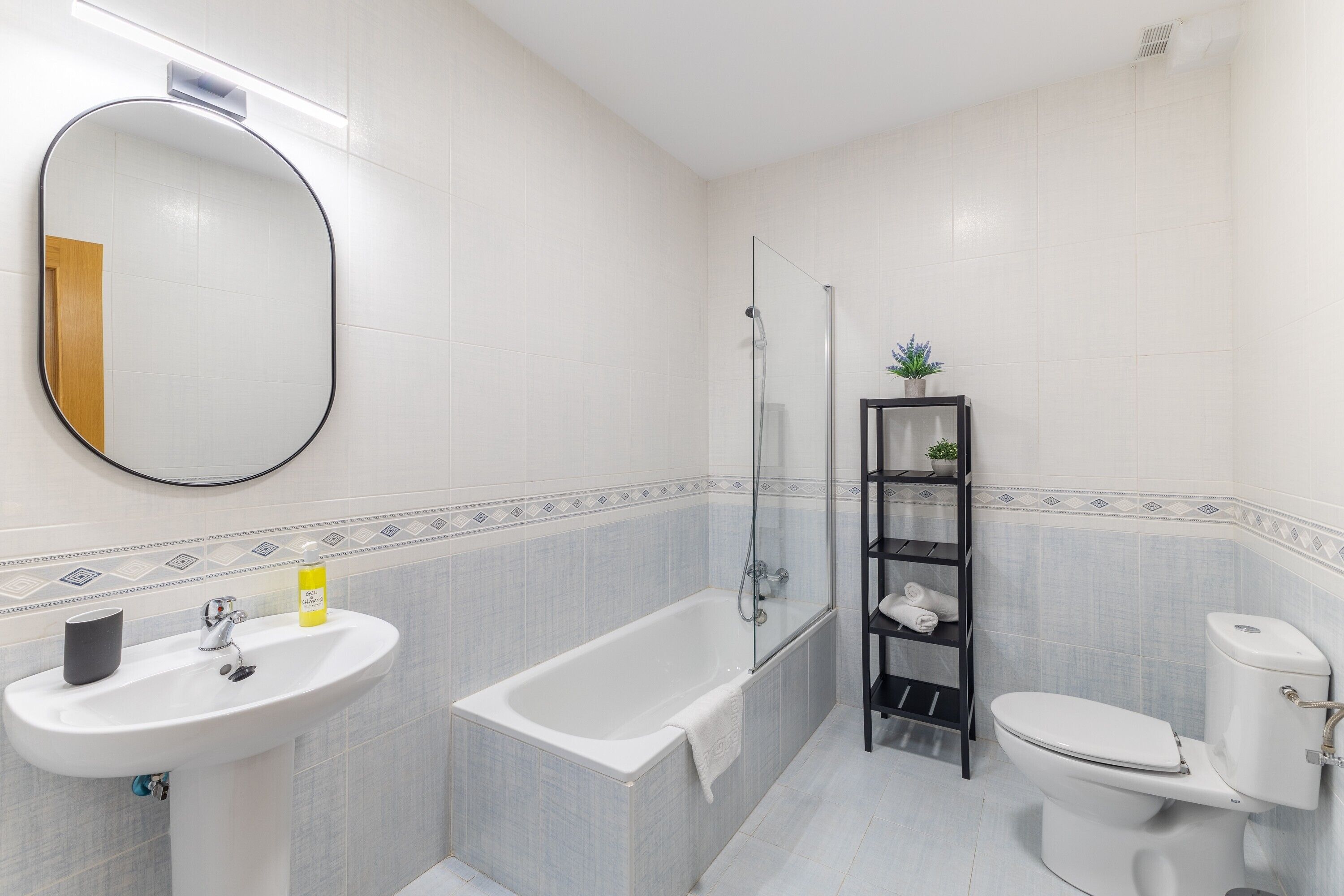 A bathroom with a sink, bathtub, toilet, and a mirror.