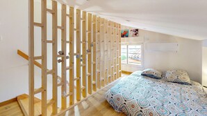 A bedroom with a bed, a wooden partition, and a window with a view of the outside. - Nice home in Royan with WiFi (Royan)