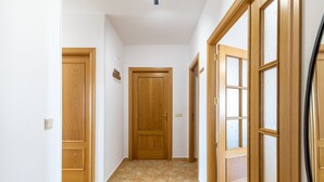A hallway with wooden doors and a tiled floor.