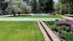 A residential area with a swimming pool, picnic tables, and a tennis court. - Elmwood Motor Court (Old Orchard Beach)