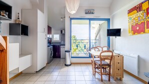 Ein kompakter Wohnraum mit Essbereich, Küchenzeile und einem Balkon mit Blick.
