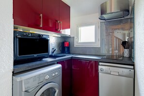 A compact kitchen with a microwave, coffee maker, and dishwasher. - The Marin’s Cabin, pool, sleeps 4 (Pornic)