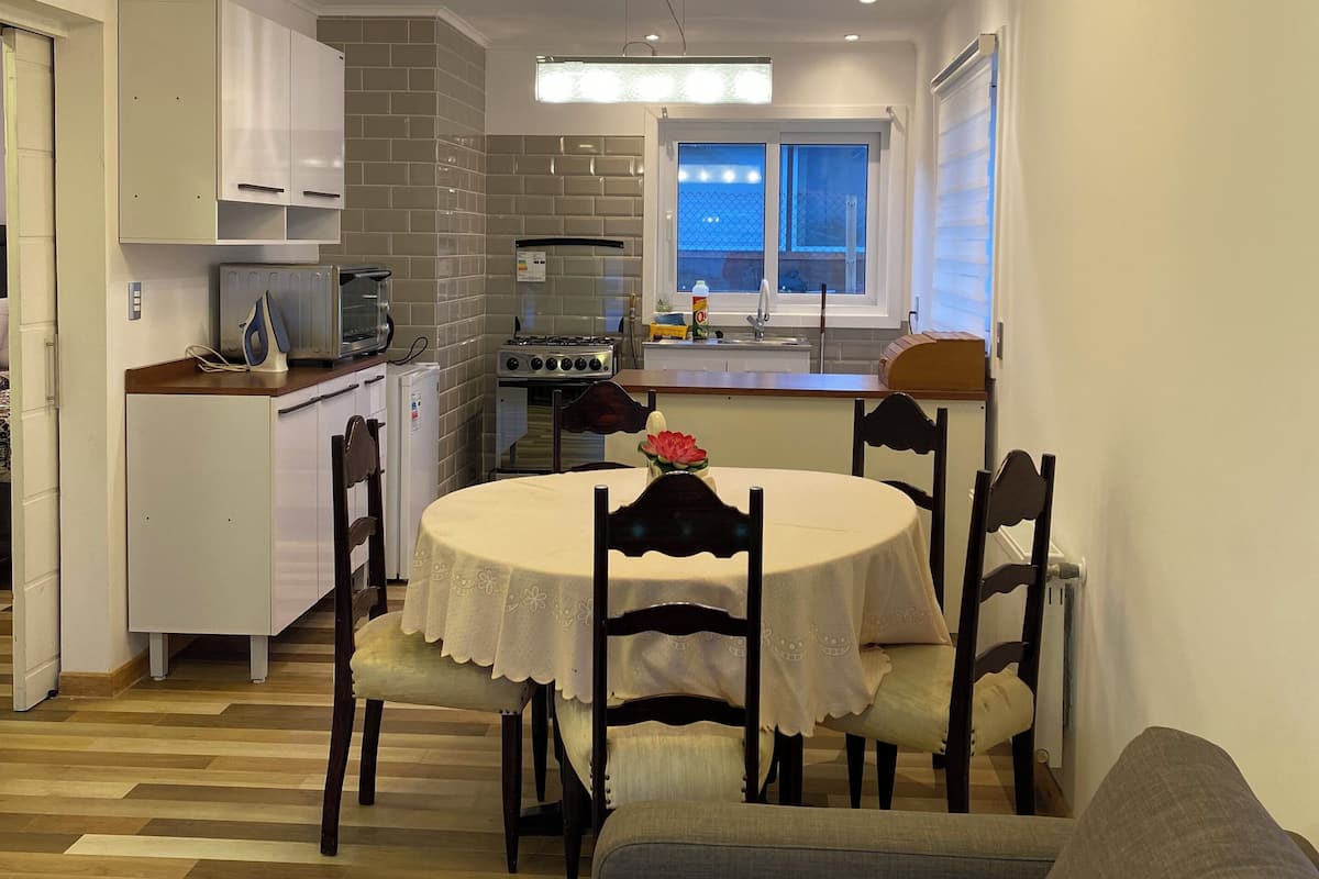 Un espace de vie compact comprenant un coin repas, une kitchenette et un canapé.