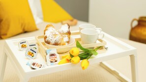 Una bandeja con pasteles, una taza de café y un tarro de Nutella.