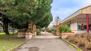 A pathway leading to a building with a mural, surrounded by trees and plants. - Between Green and Ocean, with Private Terrace - 123 (Pornic)
