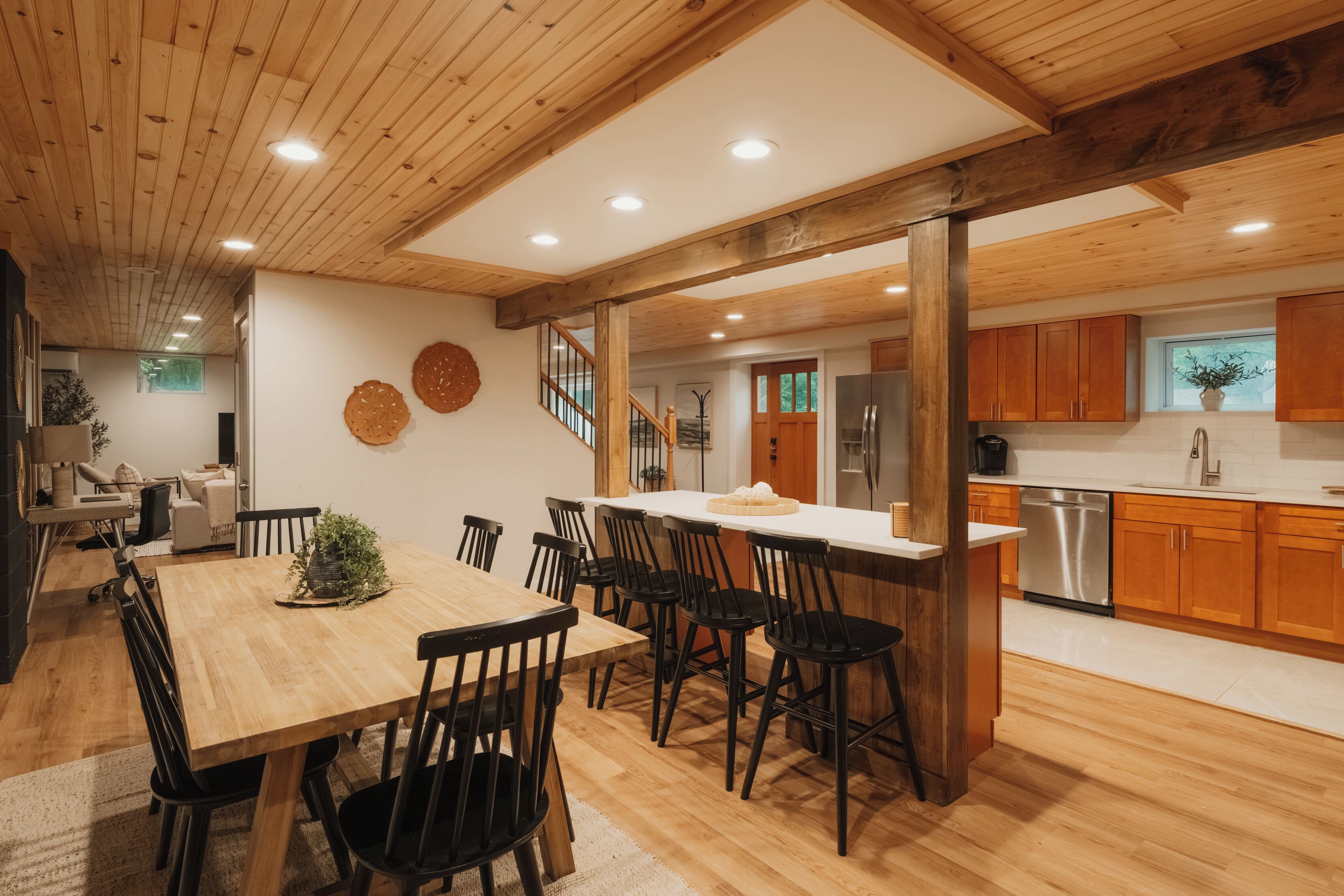 Una cocina amplia con armarios de madera, un refrigerador de acero inoxidable y un comedor con mesa y sillas de madera.