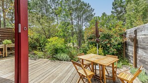 A wooden deck with a table and chairs, surrounded by a wooden fence and trees. - Holiday Home 'Home Sweet Home Moliets' with Shared Pool, Private Terrace & Wi-Fi (Moliets-et-Maa)