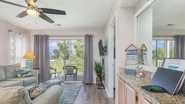 Una sala moderna con sofá, mesa de comedor y ventilador de techo.