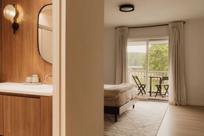 A bedroom with a bed, a balcony with chairs, and a view of greenery. - Beaver Lodge at Carter Bridge Estate (Freehold)