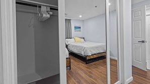A bedroom with a bed, a wardrobe, and a mirror.