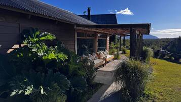 Sit on the covered porch and enjoy the serene surroundings amidst lush greenery.