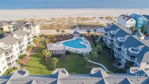 A beachfront hotel with multiple buildings, a swimming pool, and a view of the ocean. - New Listing! Tidewater Ocean View! Steps from the Beach! Screened in Porch!  (Isle of Palms)