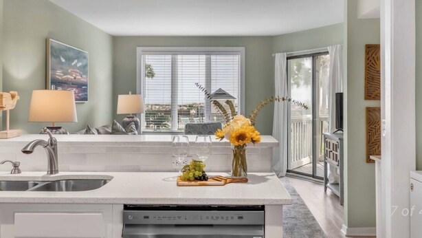 A modern kitchen with a central island, a sink, and a window with blinds. - New Listing! Tidewater Ocean View! Steps from the Beach! Screened in Porch!  (Isle of Palms)