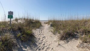A sandy beach path with a sign indicating 'Tide Water'. - New Listing! Tidewater Ocean View! Steps from the Beach! Screened in Porch!  (Isle of Palms)