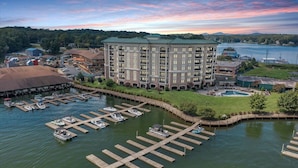 A large hotel with multiple floors and a swimming pool, surrounded by a dock with boats. - Bridgewater Pointe (Westlake Corner)