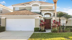 A two-story house with a garage, a front door, and a driveway.