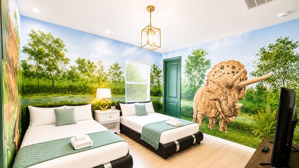 Una camera da letto con due letti, una porta verde, un murale raffigurante un paesaggio e una grande statua di dinosauro.