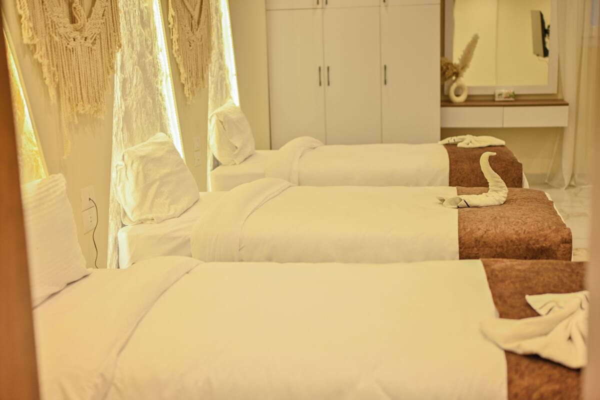 A hotel room with two beds, a large mirror, and a wardrobe.