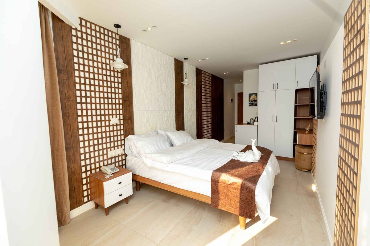 A modern bedroom with a bed, bedside table, and a wardrobe.