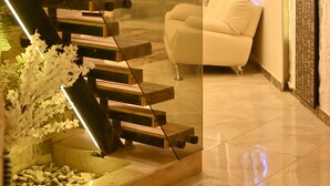 Un intérieur moderne avec un escalier, un canapé blanc et un mur décoratif.