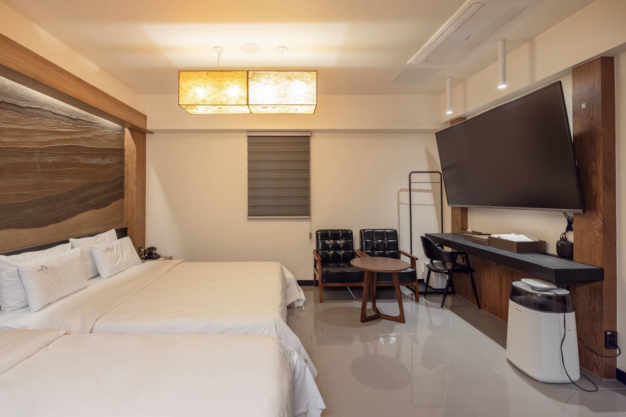 Habitación de hotel con una cama grande, un escritorio con televisión de pantalla plana, una silla y un calefactor.