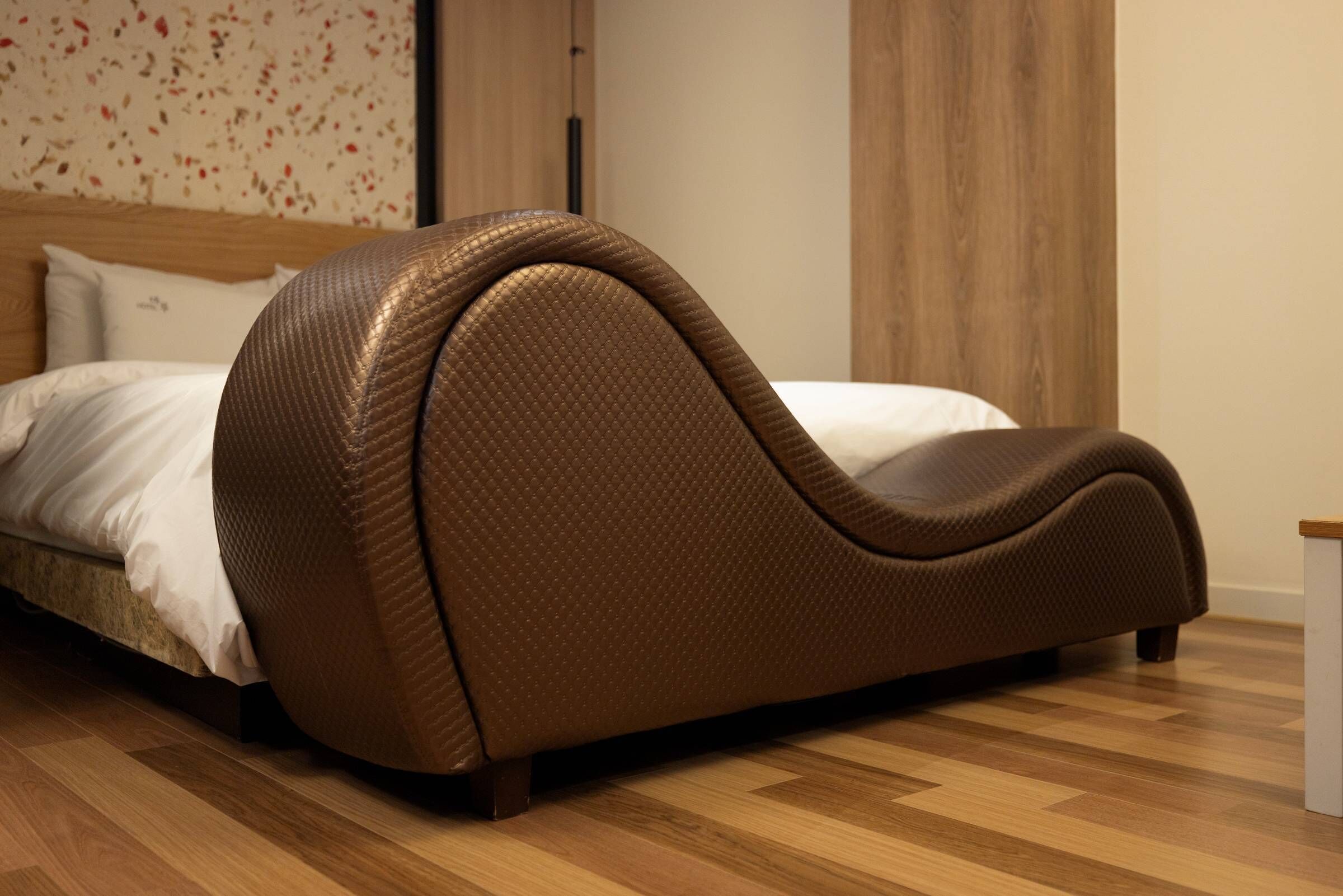 Una cama moderna con un original cabecero curvo en una habitación de hotel.
