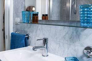 Regadera, secadora de cabello, toallas, papel de baño 