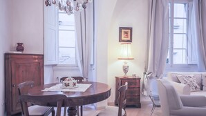 Ein Essbereich mit Holztisch, Stühlen, einer Kandelaber, einer Lampe und einer Couch.